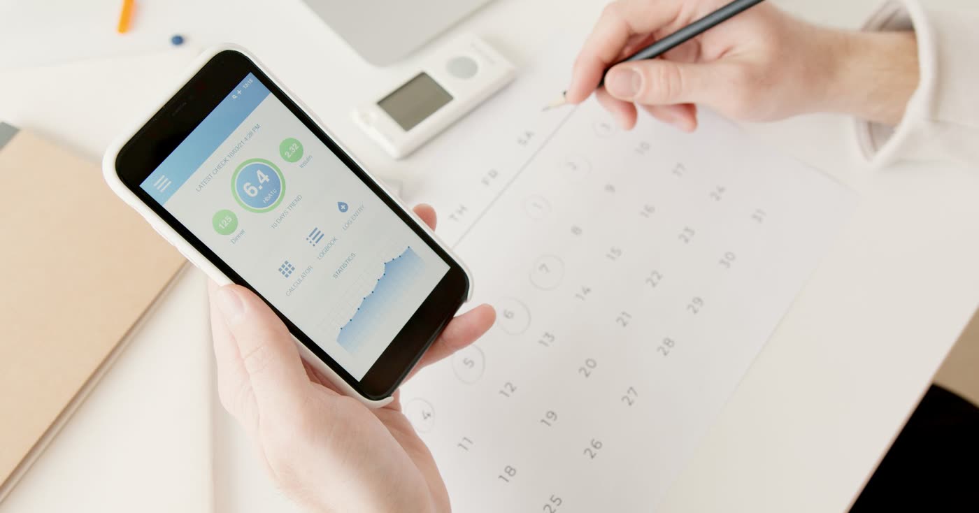A smartphone showing health tracking beside a calendar