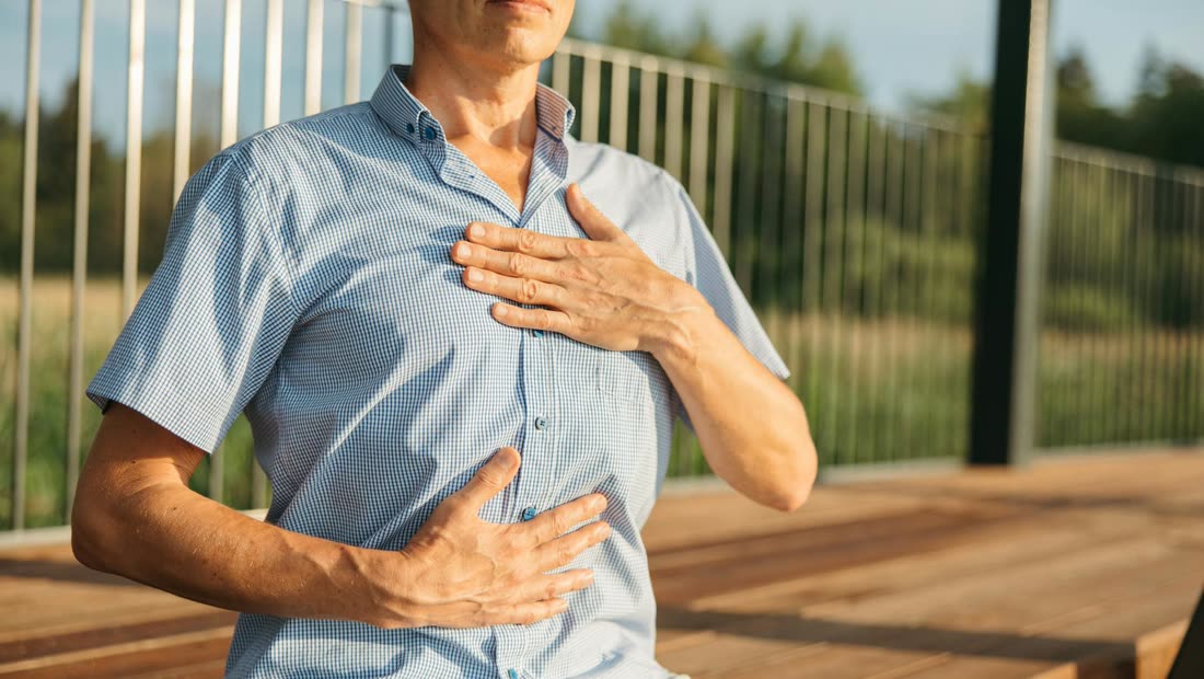 A person resting their hands on chest and abdomen while practicing a calm breathing exercise
