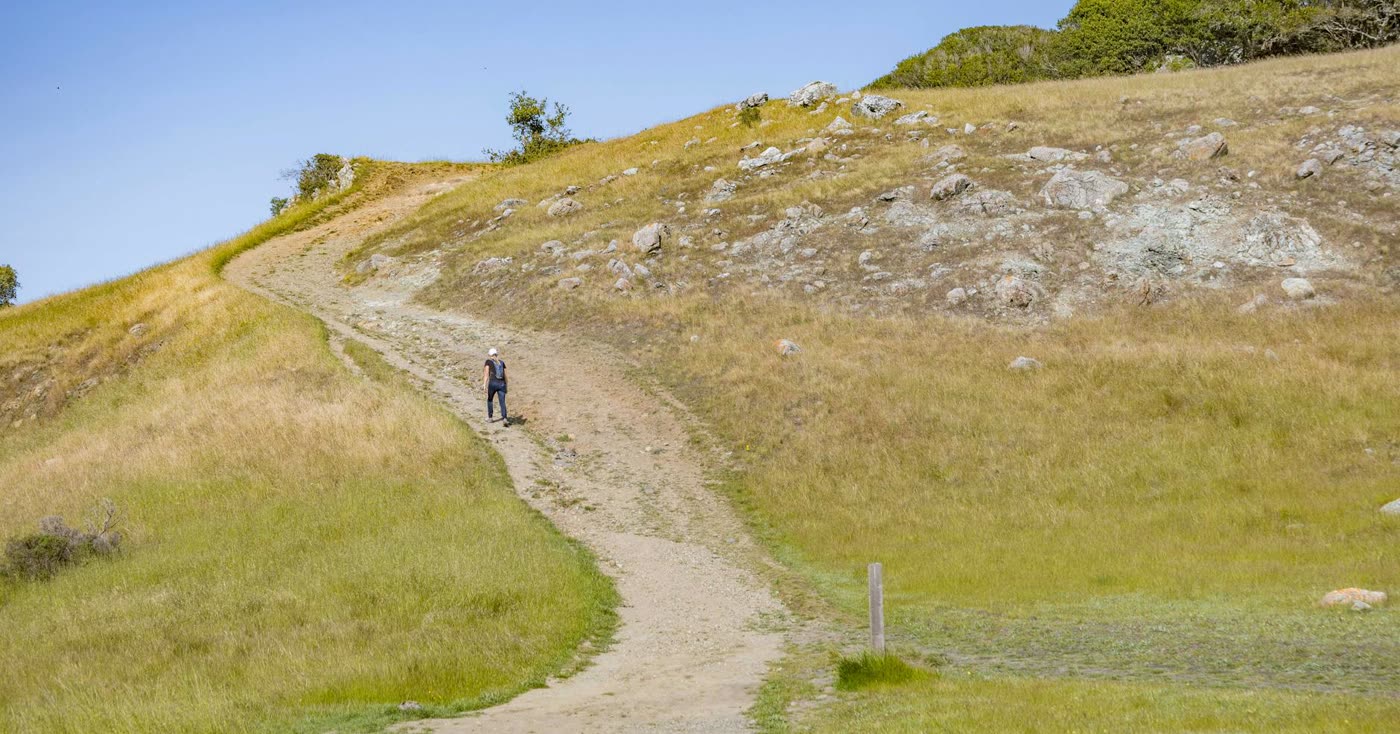 A person walking uphill on a clear trail, representing the difficult third day after quitting smoking