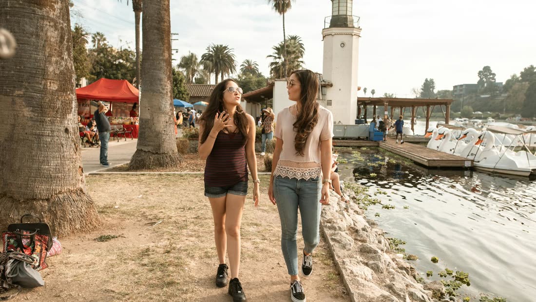 Two women walking and talking by a lake, showing support during a hard craving day