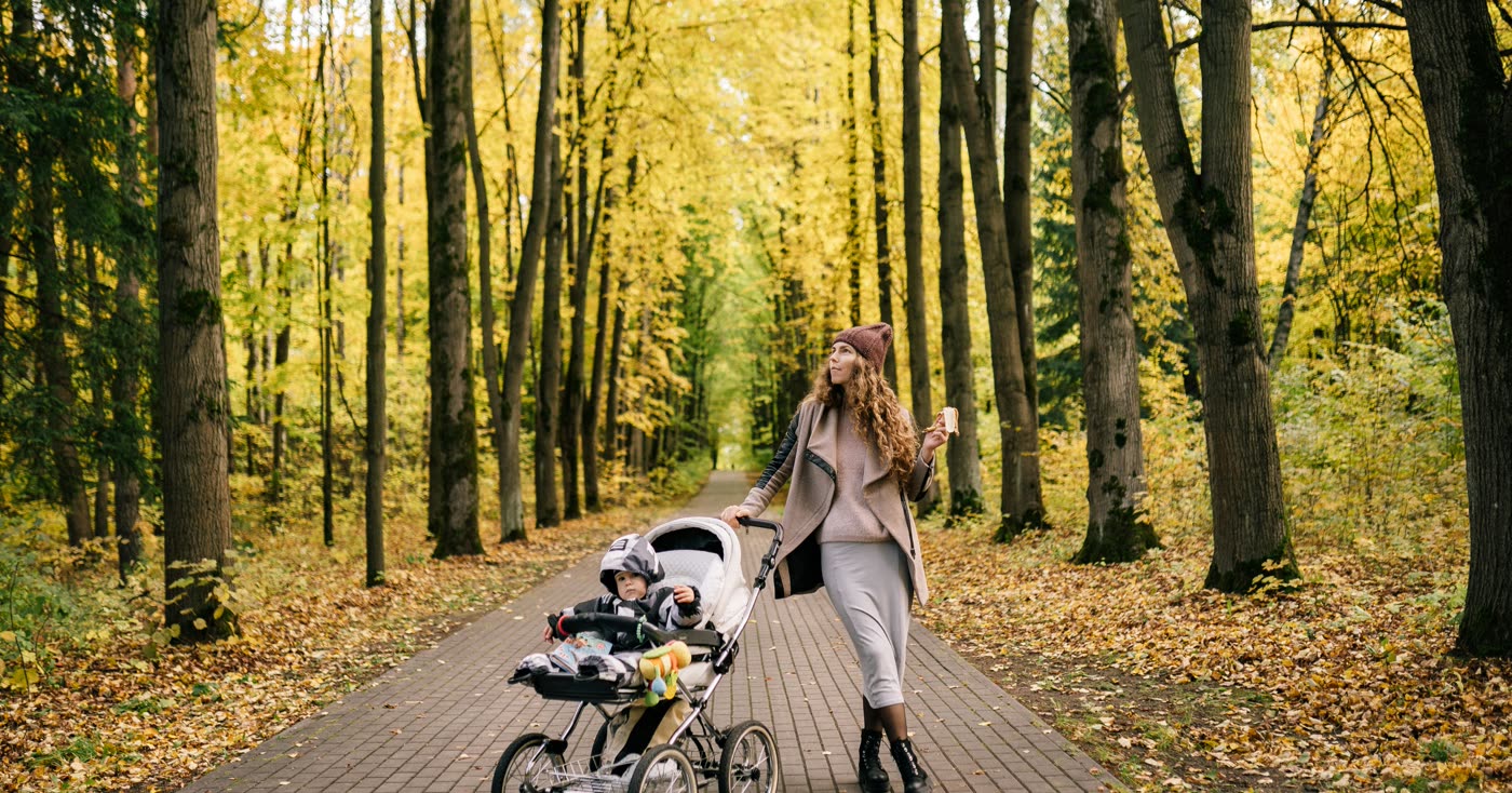 A mother and child walking through an autumn park