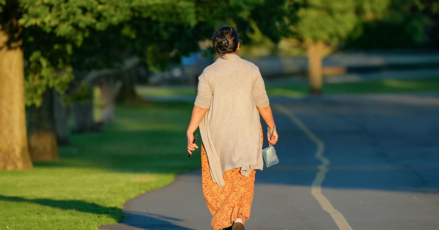 A woman walking down a sunny tree-lined path, symbolizing the first three smoke-free days