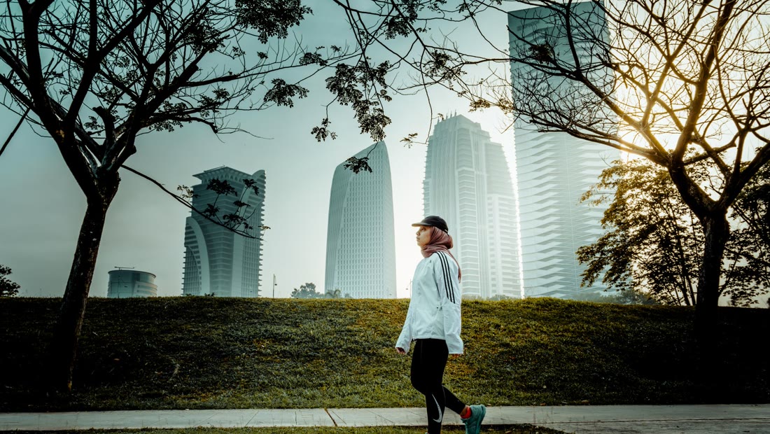 A person walking through a city park in the morning